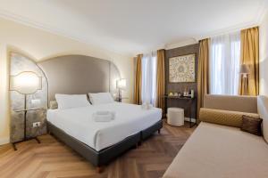 a bedroom with a large white bed and a couch at 286 Piazza San Marco - Relais il Doge in Venice