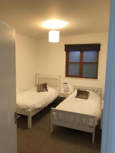 a bedroom with two beds and a window at Cosy South Gloucestershire Cabin Retreat in Yate