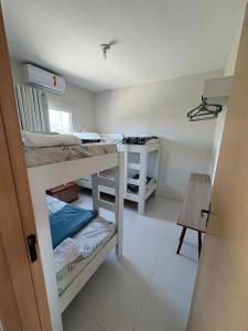 a room with two bunk beds and a table at Apartamento Beira-Rio in Barreirinhas
