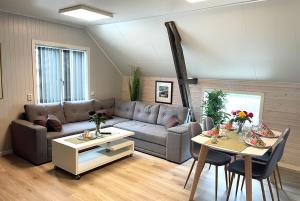 a living room with a couch and a table at Havnnes Handelssted in Hamnnes