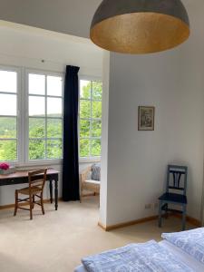 a bedroom with a table and chairs and windows at Auberge Tabarz Breitenberg in Tabarz