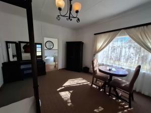 a living room with a table and chairs and a window at Mahem Guest House in Memel