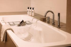 een witte gootsteen met daarop een afdruiprek bij Pillows Luxury Boutique Hotel Inter Scaldes in Kruiningen +24 foto's