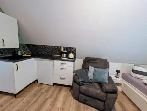 a living room with a chair and a kitchen at Komplettapartment 4, Küche, WLAN, Parkplatz in Twist +7 photos