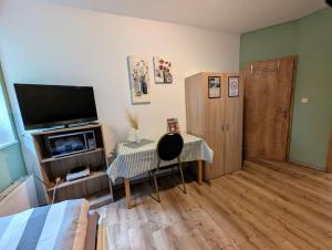a bedroom with a television and a table and a chair at Komplettapartment 4, Küche, WLAN, Parkplatz in Twist