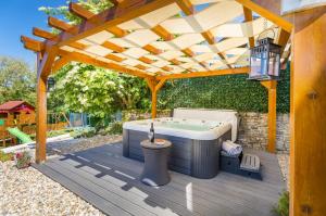 a hot tub sitting under a wooden pergola at Casa Serena in Bašići +48 photos