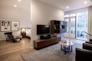 een woonkamer met een televisie en een bank bij Pillows Luxury Boutique Hotel Inter Scaldes in Kruiningen