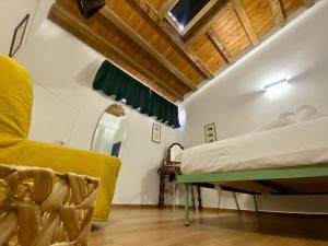 a bedroom with a bed and a chair in a room at Le Cancelle - Residenza d'epoca in LʼAquila
