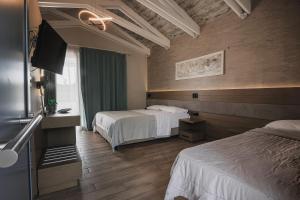 a hotel room with two beds and a television at Hotel Golden Sun in Néa Meságkala