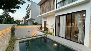 a house with a swimming pool next to a building at Dreamland View Villa #3 with Pool in Uluwatu
