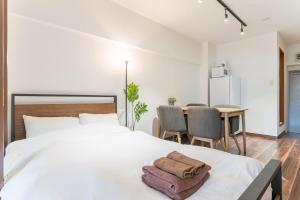 a bedroom with a white bed with two towels on it at Shibuya E-address 205 in Tokyo