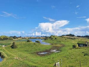 a river in the middle of a field with a house at Tranquil Retreat in Hejlsminde-By Traum in Hejls +26 photos