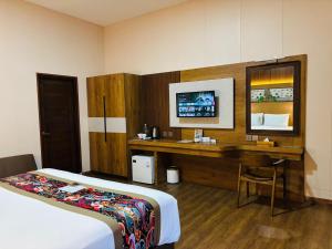 a hotel room with a bed and a desk with a computer at Adil Villa & Resort in Ubud
