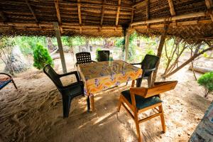 a table with four chairs and a table and a table and chairs at SSS Farm House in Cheyūr