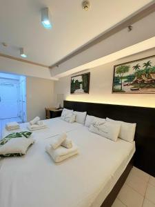 a large white bed with towels on top of it at Happynest Staycation Family Room 52 in Tagaytay