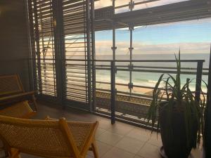 a room with a window with a view of the ocean at Coastal Luxe - Beachfront - Reduced to end Mar 2026! in Newcastle