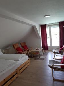 a bedroom with a bed and chairs and windows at Ferienwohnung Wolf in Nietwerder