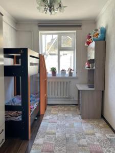 een kleine kamer met een koelkast en een raam bij Eco house in Naryn