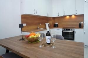 a table with two wine glasses and a bowl of fruit at Belvedere at Emerald Residence Bar in Bar