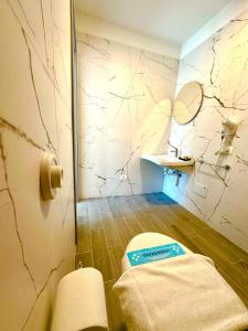 a bathroom with a toilet and a sign on the wall at Hotel Romantik & Depandance in Lignano Sabbiadoro