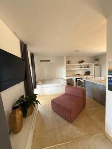 a living room with a pink chair and a couch at Holiday Home Oliva in Novalja