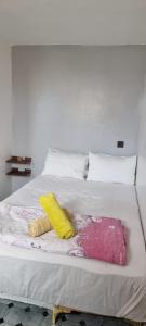 un lit blanc avec deux oreillers dessus dans l'établissement Room Taghazout, à Taghazout