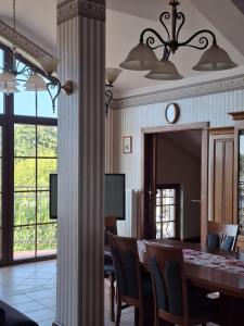 a dining room with a table and a clock on a wall at Pensjonat Oleńka in Ustka
