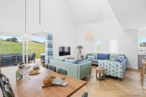 a living room with blue couches and a table at No 9 The Vista, Willingcott, Woolacombe in Woolacombe