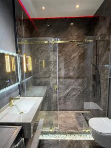 Un baño con ducha, lavabo e inodoro. en Golden House Luxury, en Toshkent-Passajir Bekati