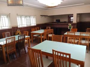 a dining room with tables and wooden chairs at Lake 47 Suites Ltd in Abuja