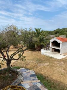 a stone oven in a yard with a tree at Holiday Home Oliva in Novalja +7 photos