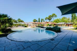 una piscina in un cortile con ombrelloni di Appartement de type 2 cabine pour 4 personnes a Parentis-en-Born