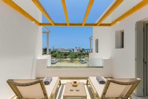 a dining room with a table and chairs and a large window at Porto Drio Seaside Residence in Drios