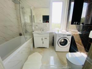 ein Badezimmer mit Waschmaschine und Waschbecken in der Unterkunft Apartament Chisinau in Chişinău + 51 Fotos