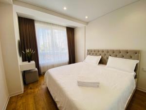ein Schlafzimmer mit einem großen weißen Bett mit einem Fenster in der Unterkunft Apartament Chisinau in Chişinău