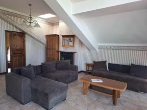 a living room with two couches and a coffee table at Pensjonat Oleńka in Ustka