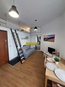 ein Wohnzimmer mit einem Sofa und einer Leiter in der Unterkunft Old Town Stage The Studio Suite Quartet in Krakau + 140 Fotos