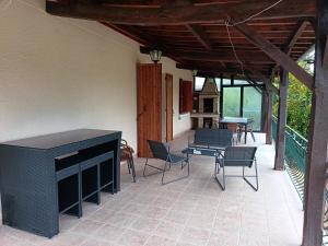 a patio with chairs and a table and a fireplace at Quiétude Quercynoise in Puy-lʼÉvêque