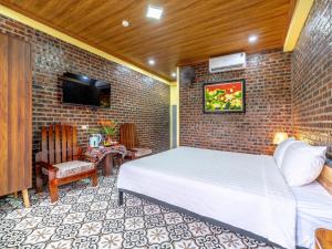 Un dormitorio con una cama y una pared de ladrillo. en Cozy Son Hotel, en Ninh Binh