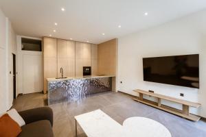 a living room with a large flat screen tv at HUGme Suite in Kalithies