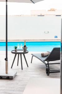 a chair and a table in a room with a pool at Villa Ixoria Unit 1 with Private Pool by ArcoCollection in St. Julianʼs