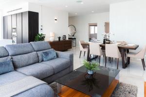a living room with a couch and a dining room at Villa Ixoria Unit 1 with Private Pool by ArcoCollection in St. Julianʼs