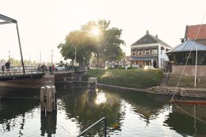 ein Gewässer mit einem Haus im Hintergrund in der Unterkunft Hotel Medemblik in Medemblik