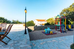a playground with a play set and a table at Villa Sky with pool in Vrh