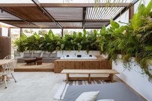 Un patio con un montón de plantas y un banco. en HUGme Suite, en Kalithies