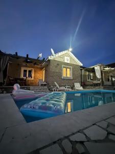 a swimming pool with a house in the background at Sun Place Bigova in Bigova