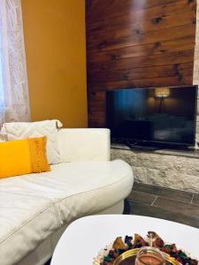 a living room with a white couch and a flat screen tv at Sun Place Bigova in Bigova