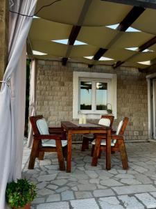 a wooden table and chairs on a patio at Sun Place Bigova in Bigova