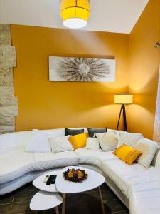 a living room with a white couch and yellow walls at Sun Place Bigova in Bigova +10 photos