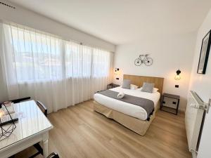 a bedroom with a bed and a large window at Hotel Maison Forge - Ex Hotel ASTORIA- Saint Etienne-Centre des Congrès- in Saint-Étienne +91 photos